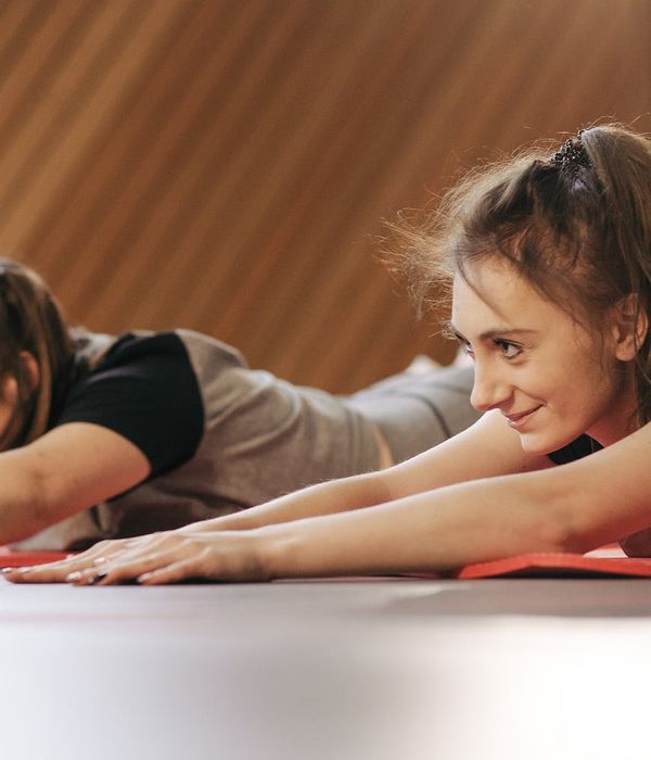 Woman performing a simple yoga pose in a bright studio environment.